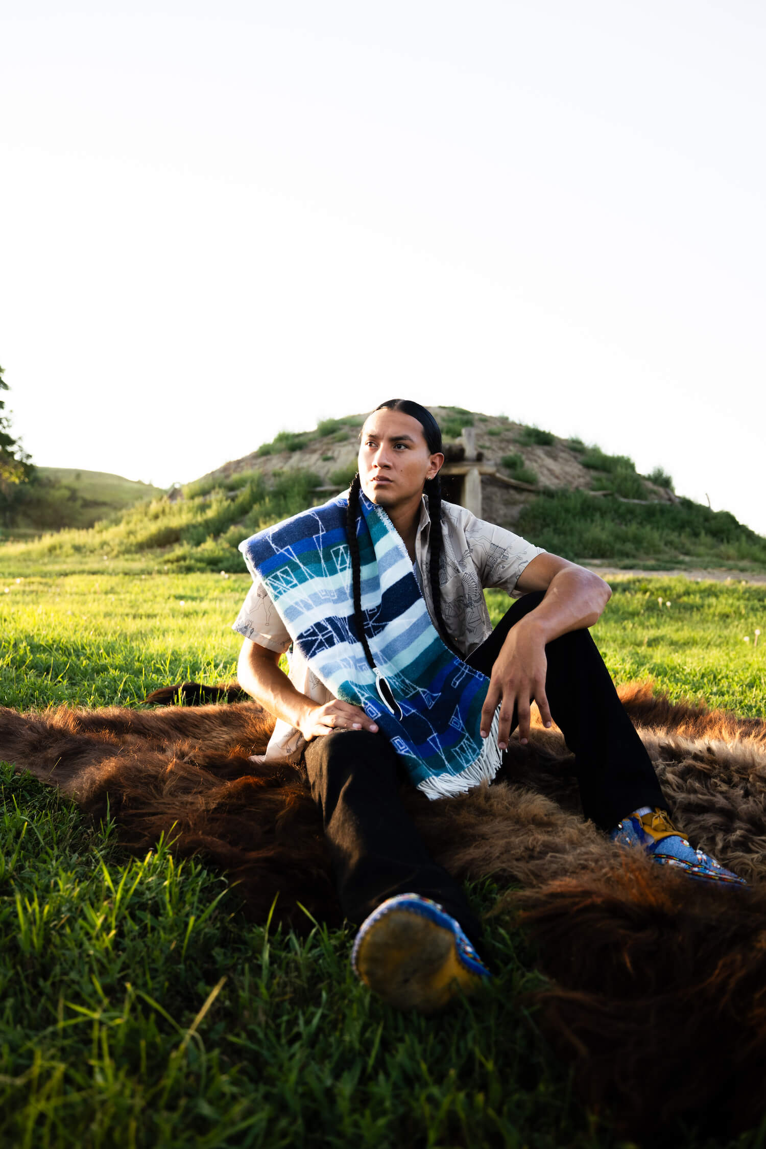 Person sitting on a horse in a grassy field with a scenic background