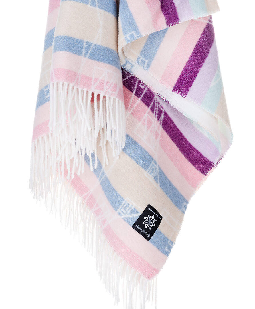 Multicolored plaid blanket with fringes on a white background