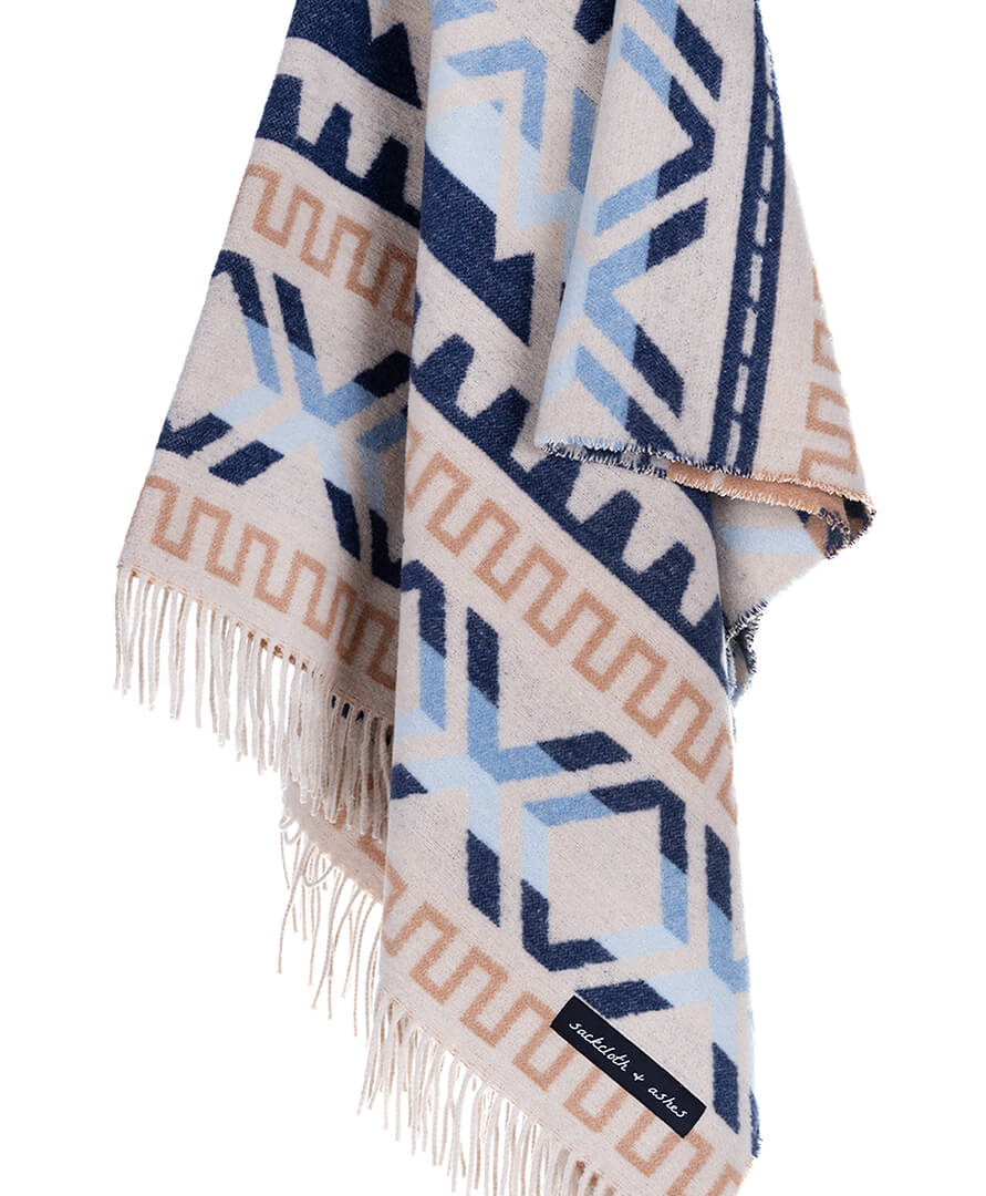 Patterned blanket with fringes on a white background