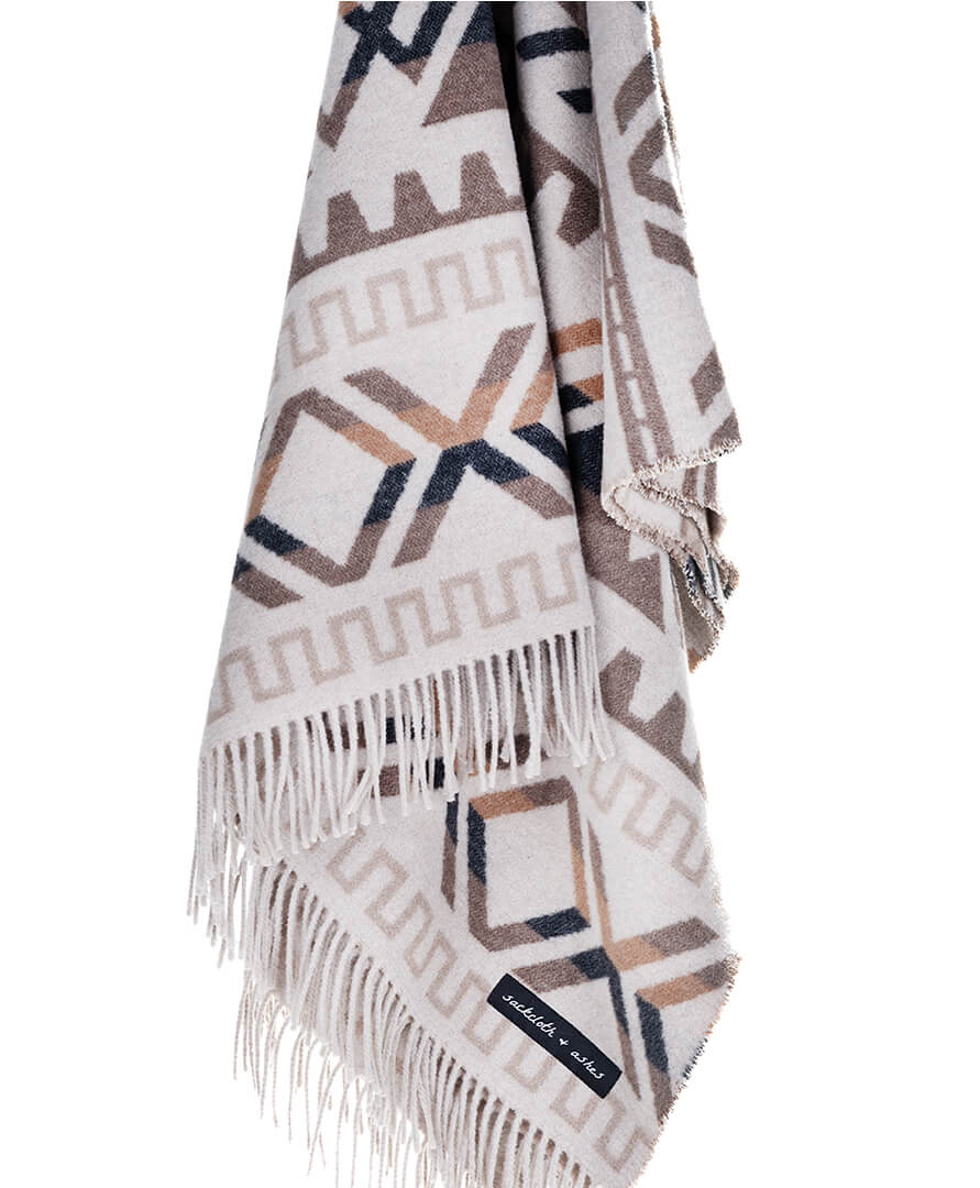 Patterned blanket with fringes on a white background