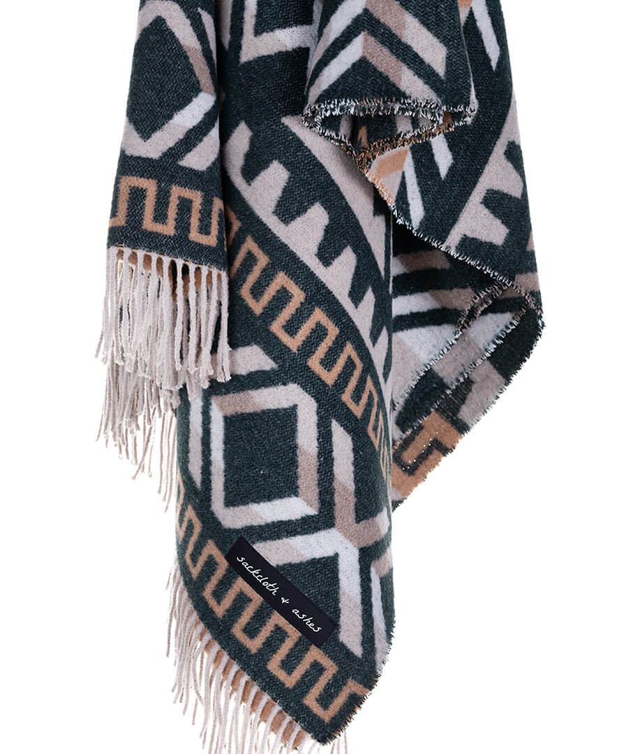 Geometric patterned blanket with fringes on a white background