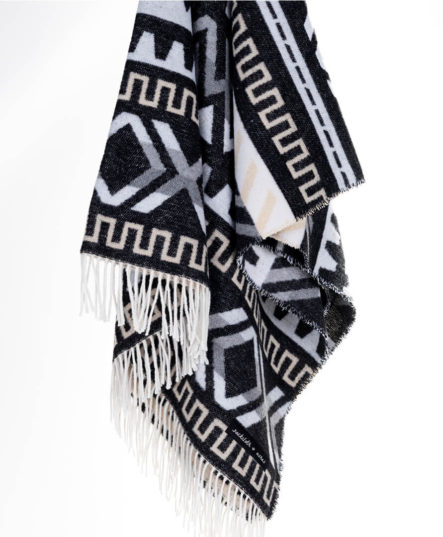 Black and white patterned scarf with fringes on a white background