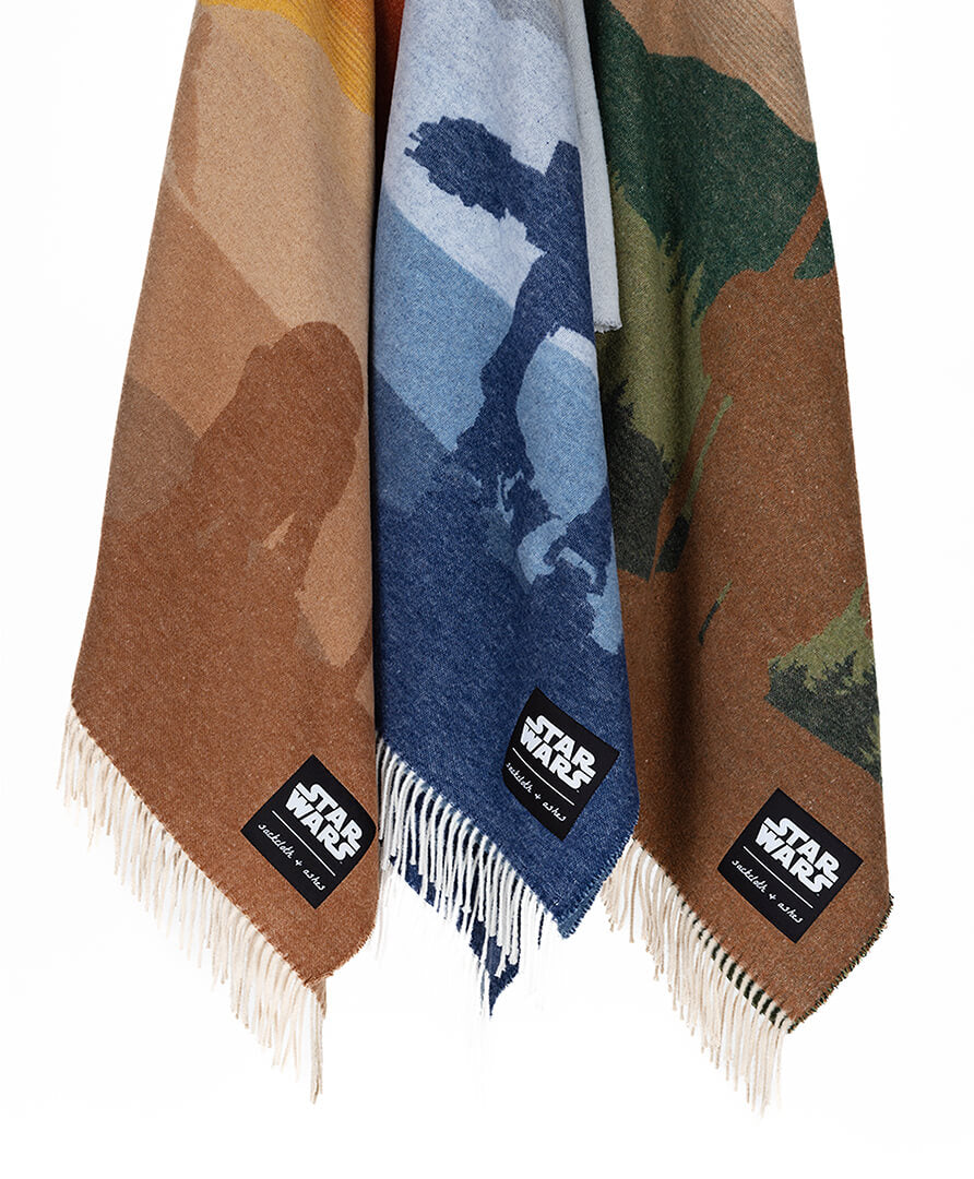 Three Star Wars-themed scarves with landscape designs and branded labels on a white background.