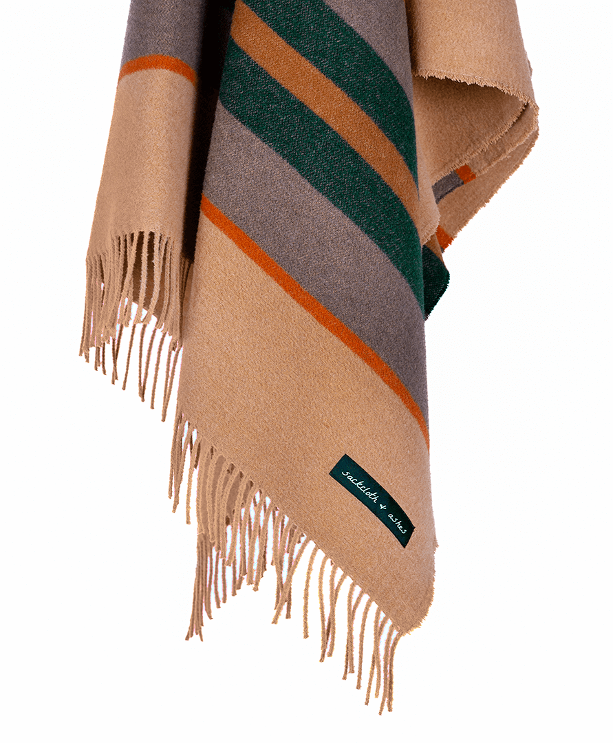 Striped blanket with fringes and a brand label on a white background