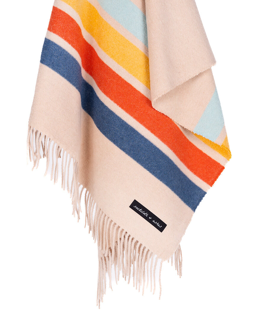 Colorful striped blanket with fringes on a white background