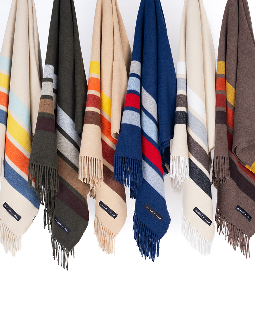 Collection of striped blankets in various colors on a white background