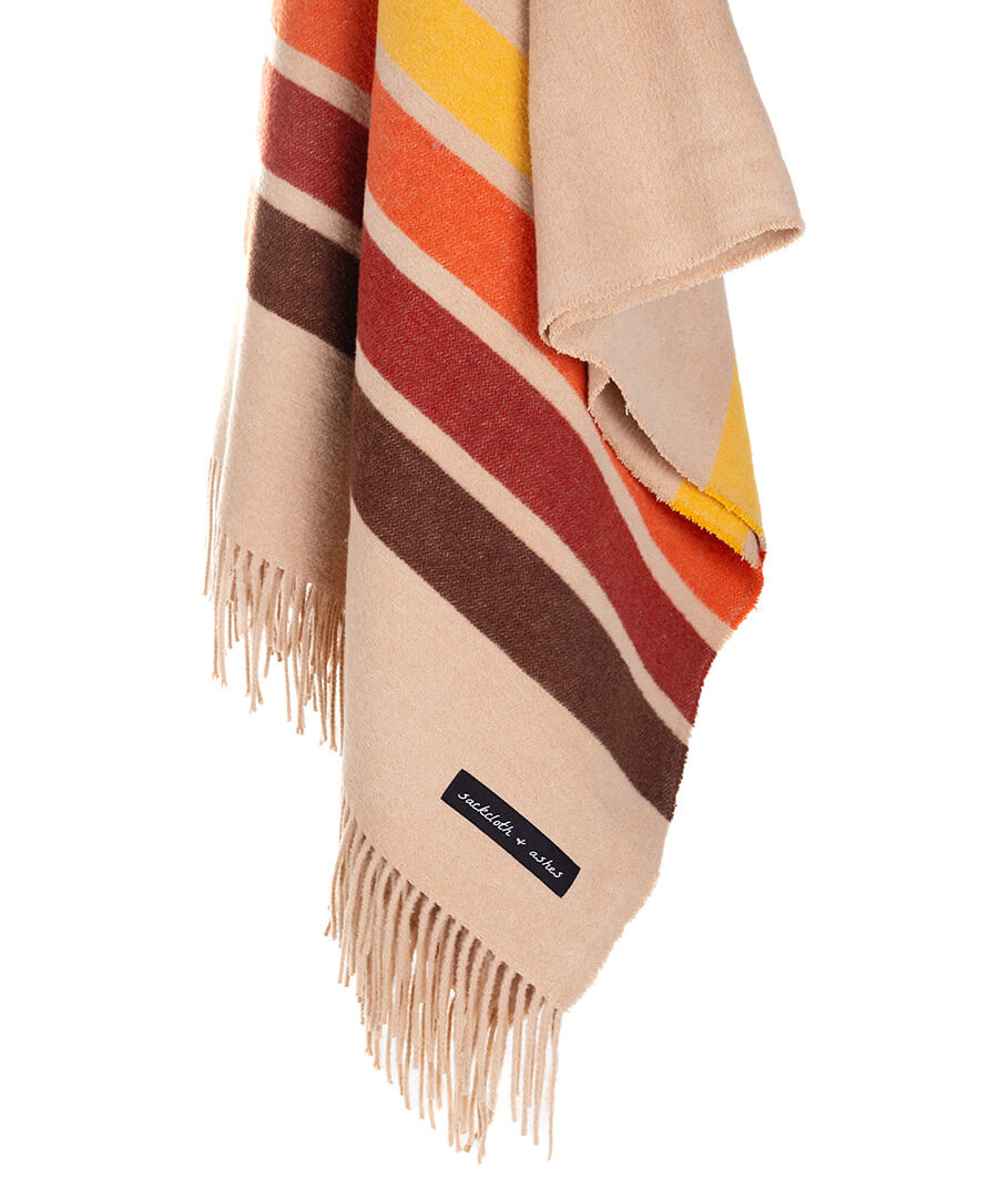 Colorful striped blanket with fringes on a white background