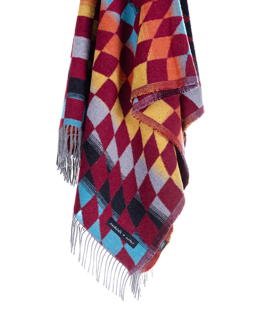 Colorful plaid blanket with fringes on a white background