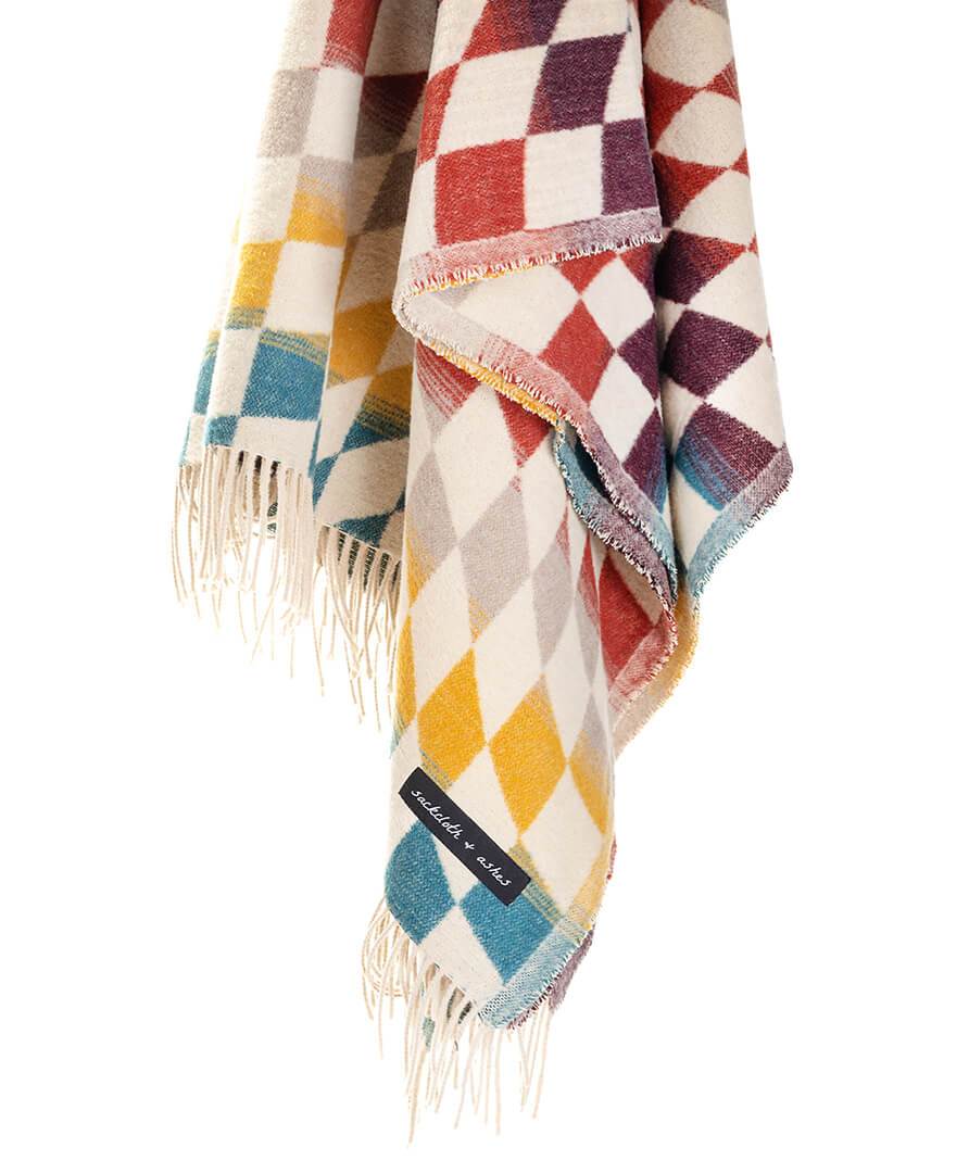 Multicolored checkered blanket with fringes on a white background
