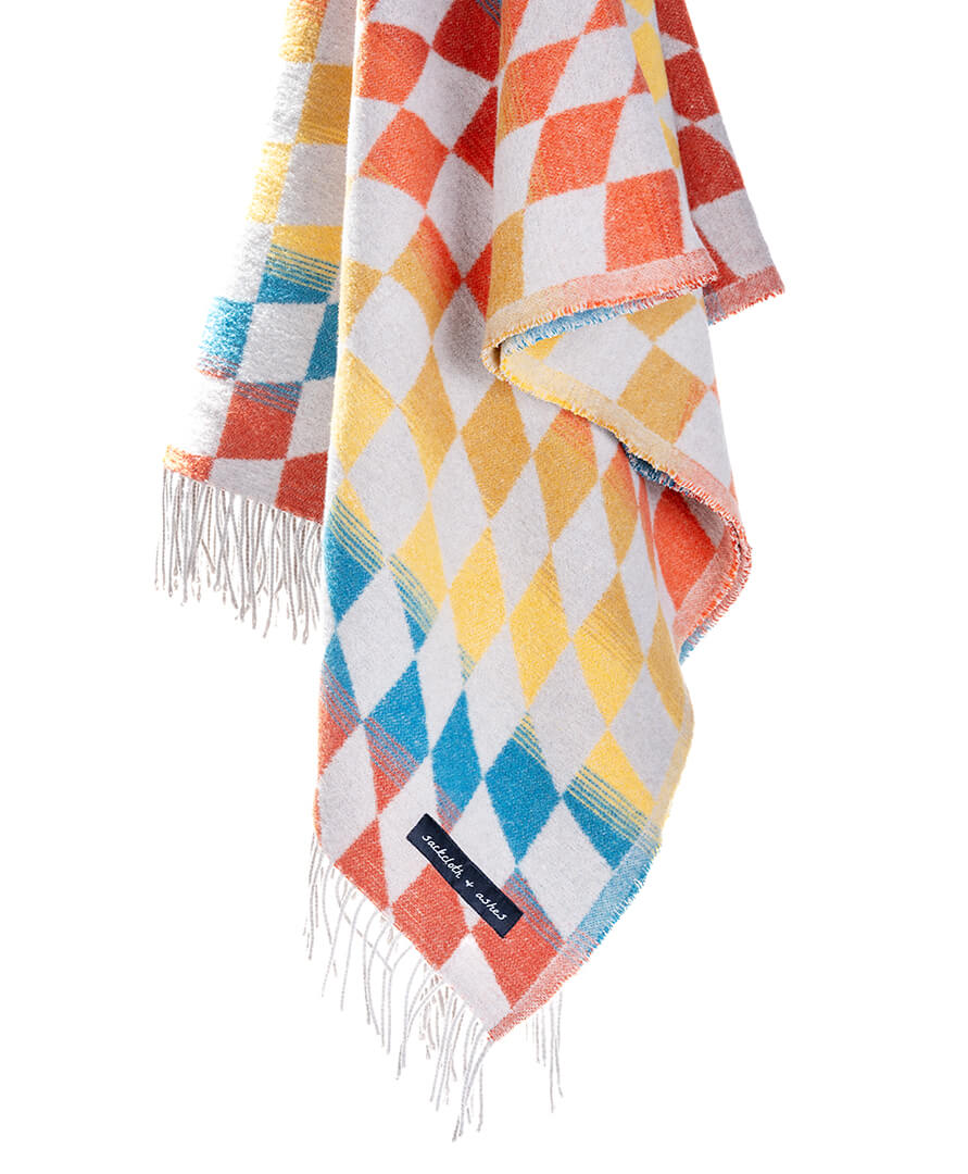 Colorful checkered blanket with fringes on a white background