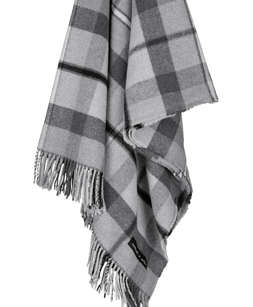 Plaid blanket with fringes and a brand logo on a white background