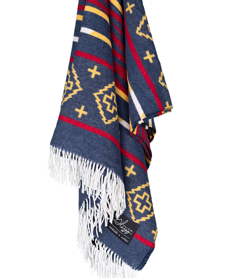 Colorful patterned blanket with fringes on a white background