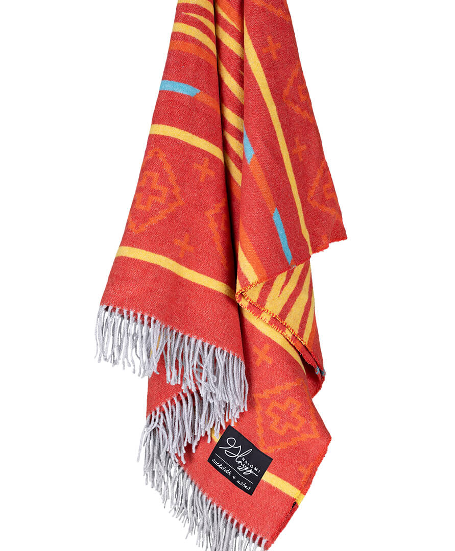 Red and yellow patterned towel with white fringe on a white background