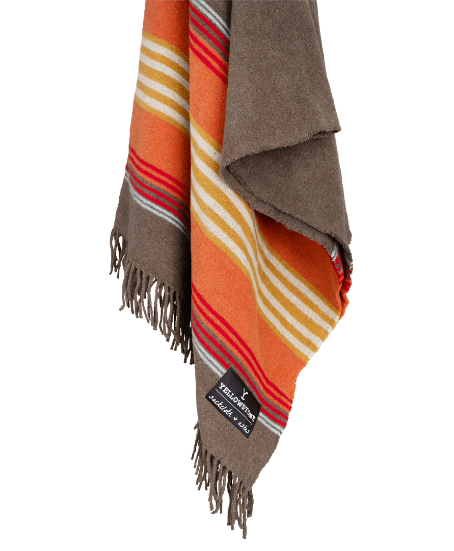 Striped blanket with fringes and a visible brand label on a black background
