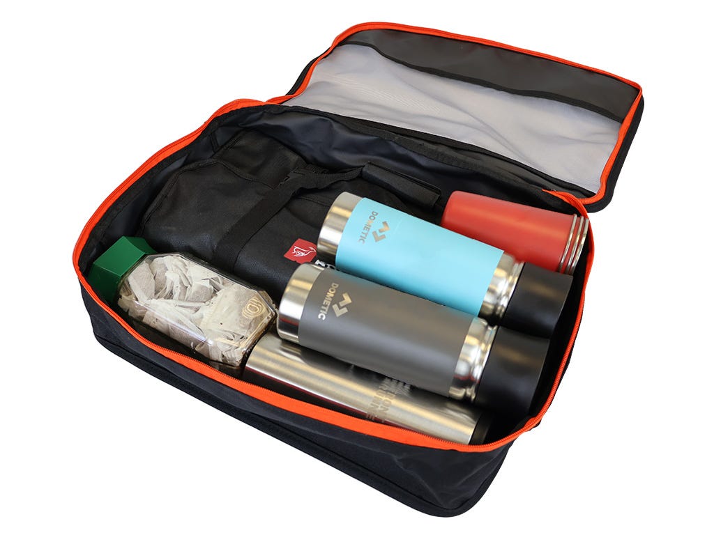 Open suitcase with travel accessories including two thermos bottles and a red item.