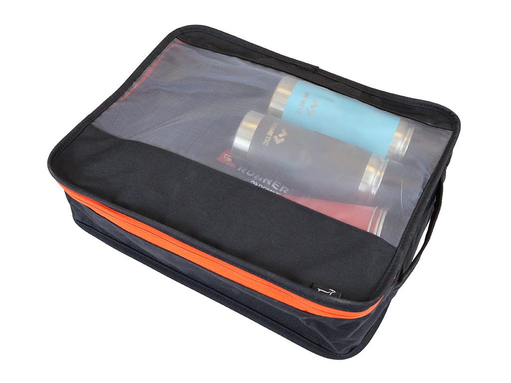 Black travel pouch with orange zipper containing bottles on a white background