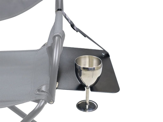 Metallic wine glass on a black tray attached to a gray chair with a white background
